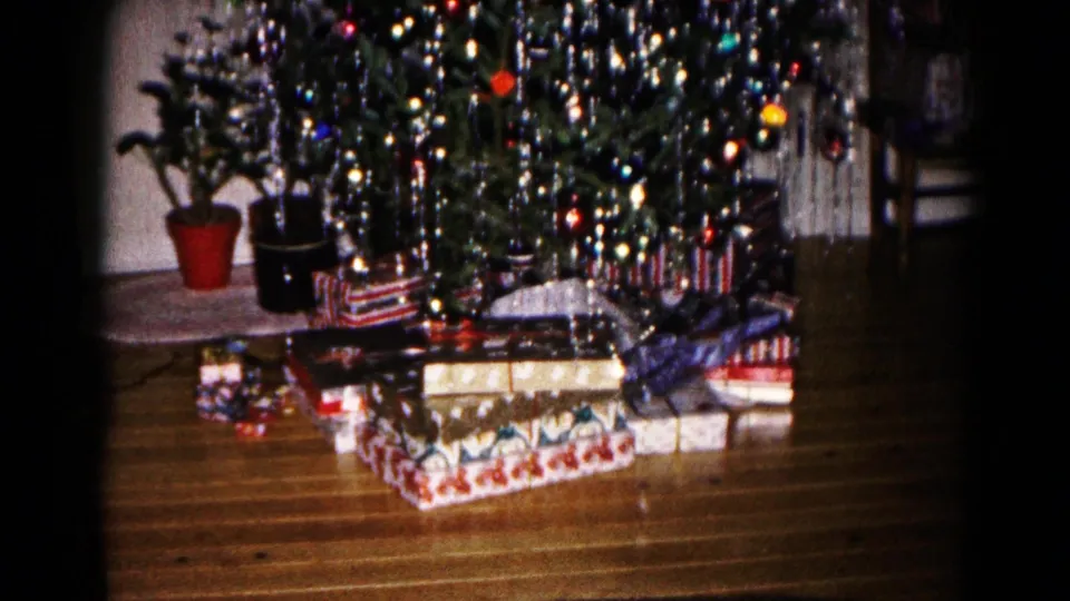 Wrapped Christmas presents sit below a tinsel-covered tree in the Hagerstown 1959 home-movie interior.