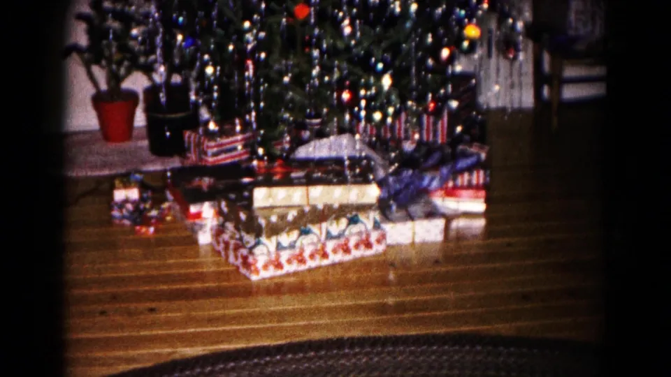 A wider 1959 Hagerstown frame shows the Christmas tree display with presents spread across the wood floor beneath it.