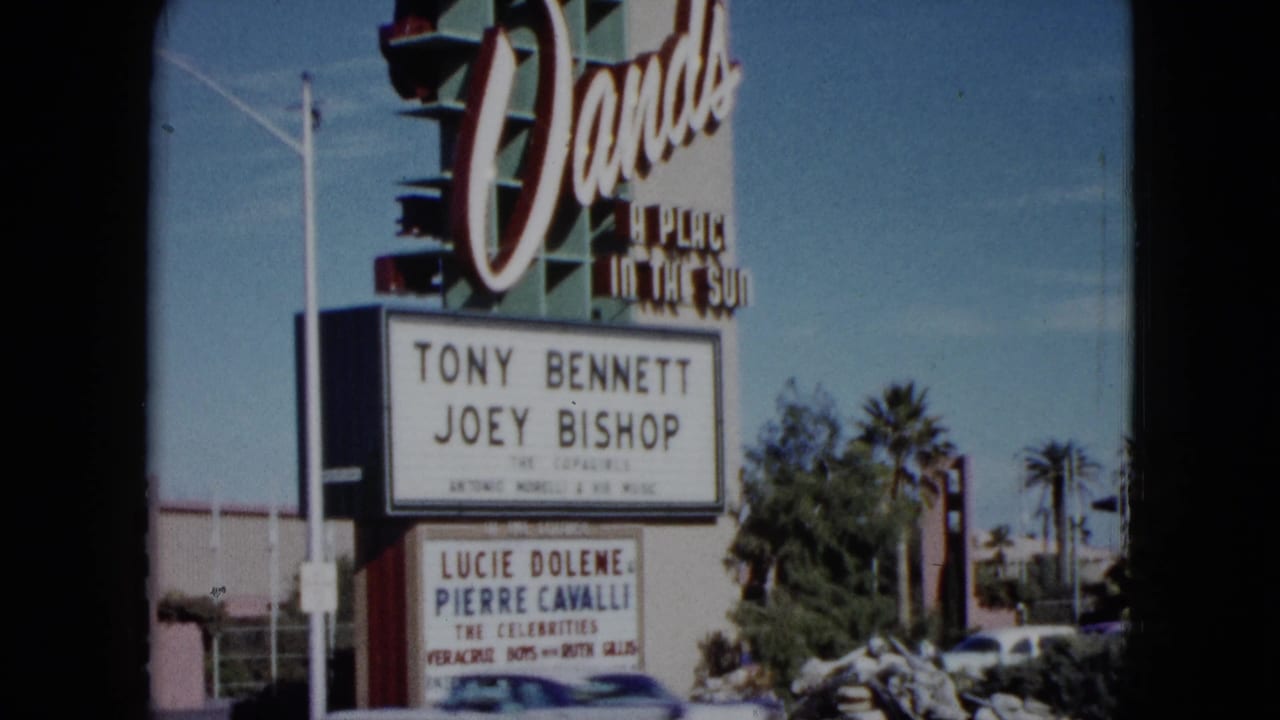 Dunes sign with marquee, palm trees, and roadside landscaping.