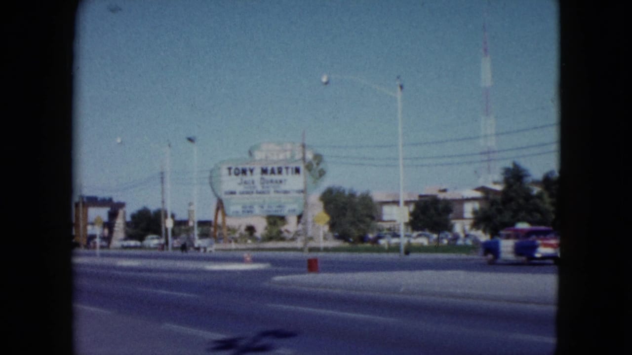 1959 Nevada street scene with the Tony Martin and Jack Durant sign, utility poles, low buildings, and a blue-and-white Volkswagen bus moving past.