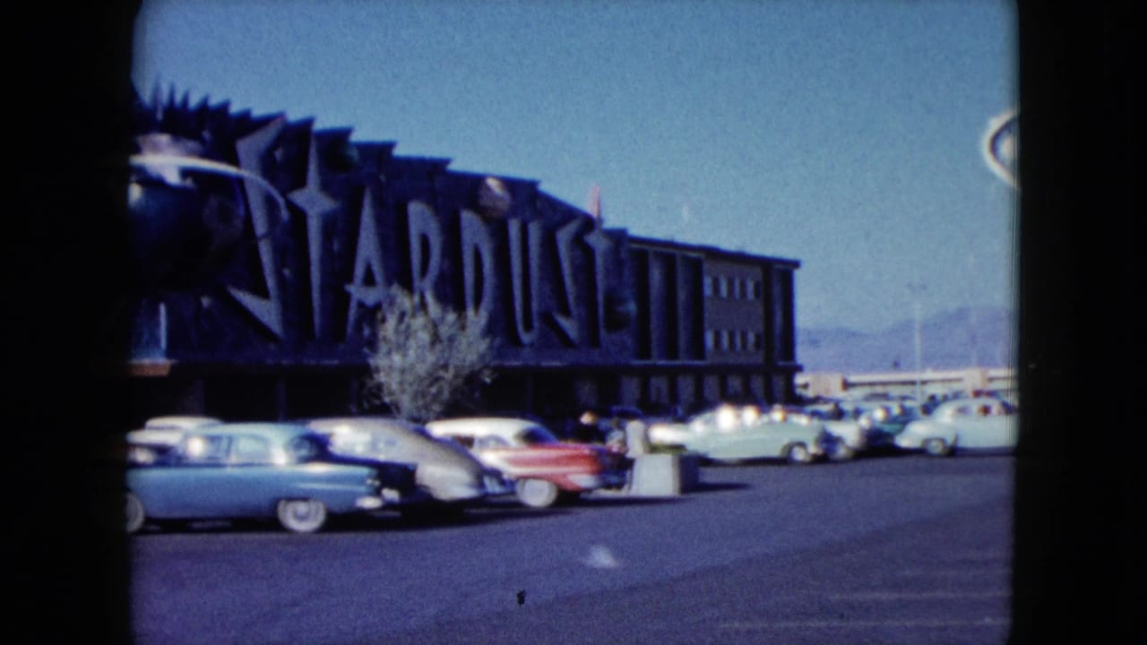 Stardust bowling facade with parked cars and a bright desert sky.