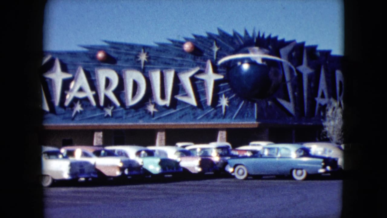 Closer view of the Stardust sign with parked cars lined up below.