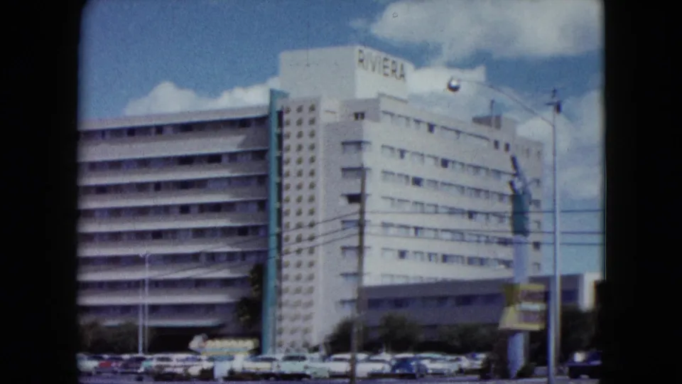 1959 home-movie frame of the Riviera hotel exterior with period cars and street infrastructure visible.