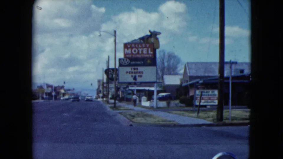 Closer 1959 Nevada street view with motel signage, roadside buildings, and sparse traffic.