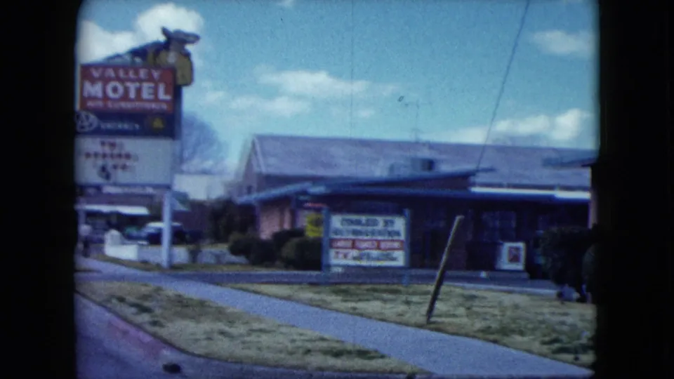 1959 Nevada roadside view of a Valley Motel sign beside a low motel building under a blue sky.