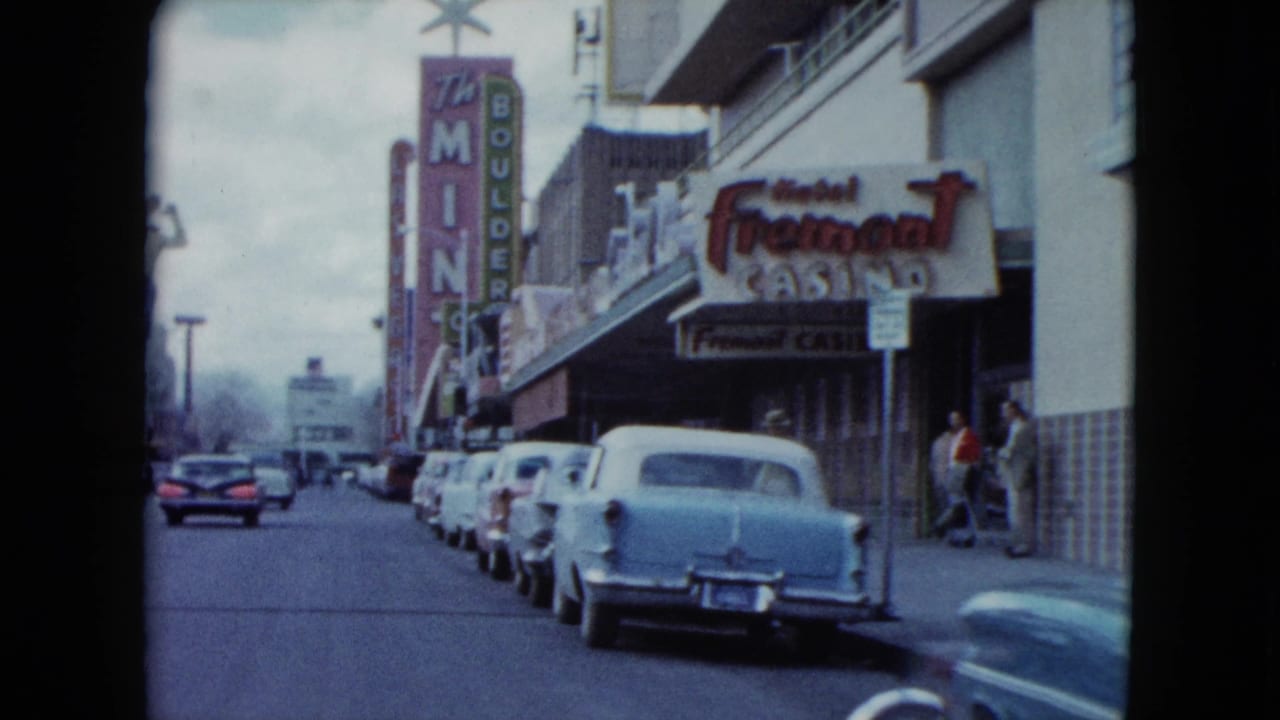 Street view passing the Fremont Casino sign with rows of parked cars and neon signage.