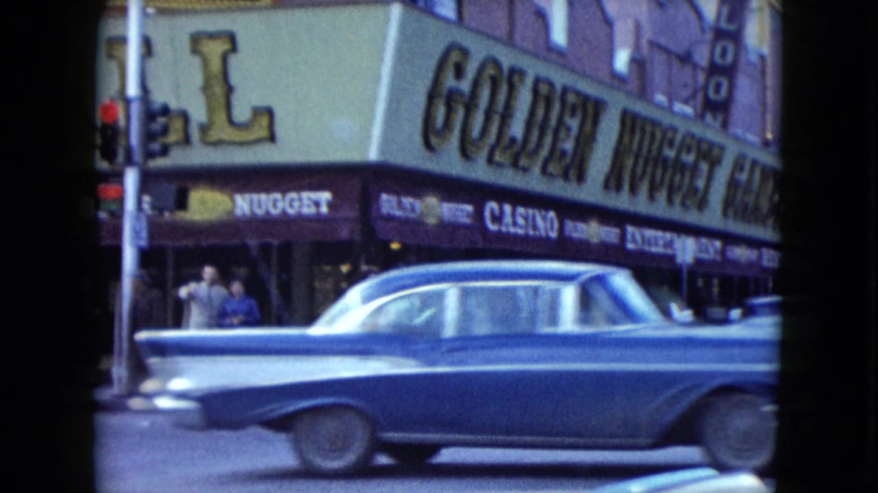 1959 Nevada street view with a blue sedan passing the Golden Nugget marquee and casino awning.