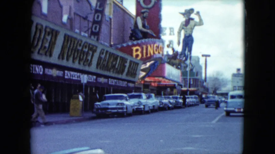 1959 Nevada view of the Golden Nugget frontage with neon bingo signage, a western figure, and parked mid-century cars.