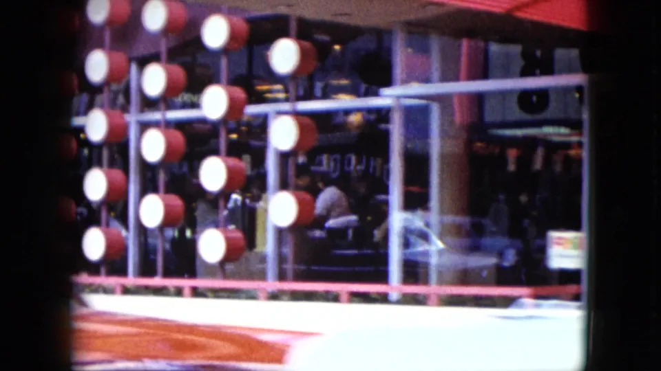 1959 Nevada storefront detail with round exterior lights, red trim, glass windows, and people faintly visible inside.