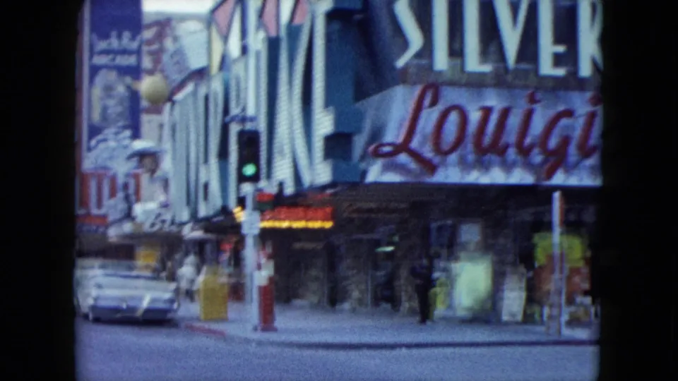 Nevada street view with large Silver and Lounge signage, a traffic signal, pedestrians, and a parked classic car near storefront windows.