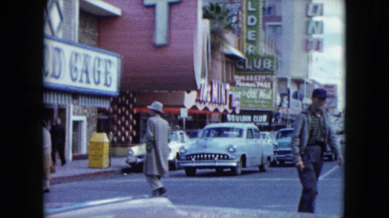 Nevada street scene from supplied 1959 metadata with pedestrians crossing near classic cars, Bird Cage signage, and Boulder Club storefronts.