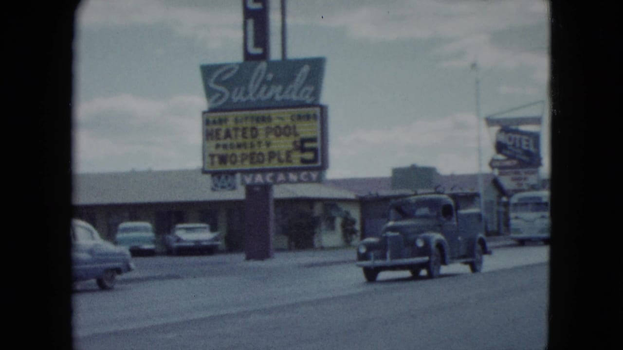 Salinda Motel sign beside a roadside motel with cars parked near the entrance.