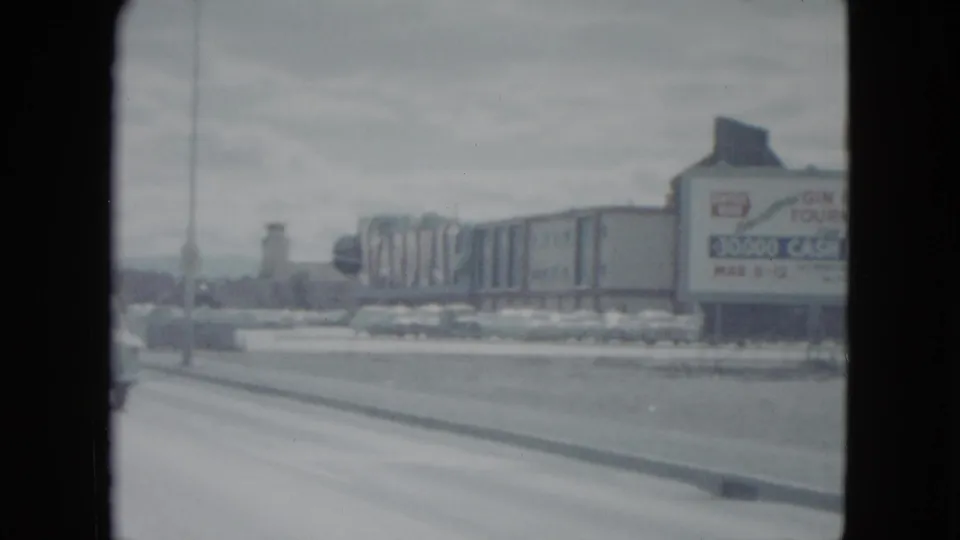 1959 Nevada roadside view with a large prize-tournament sign, parked cars, and commercial structures.
