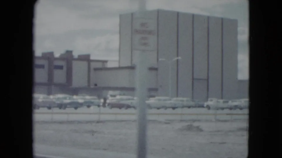 1959 Nevada street view of a large commercial building, parking area, cars, and a roadside pole.