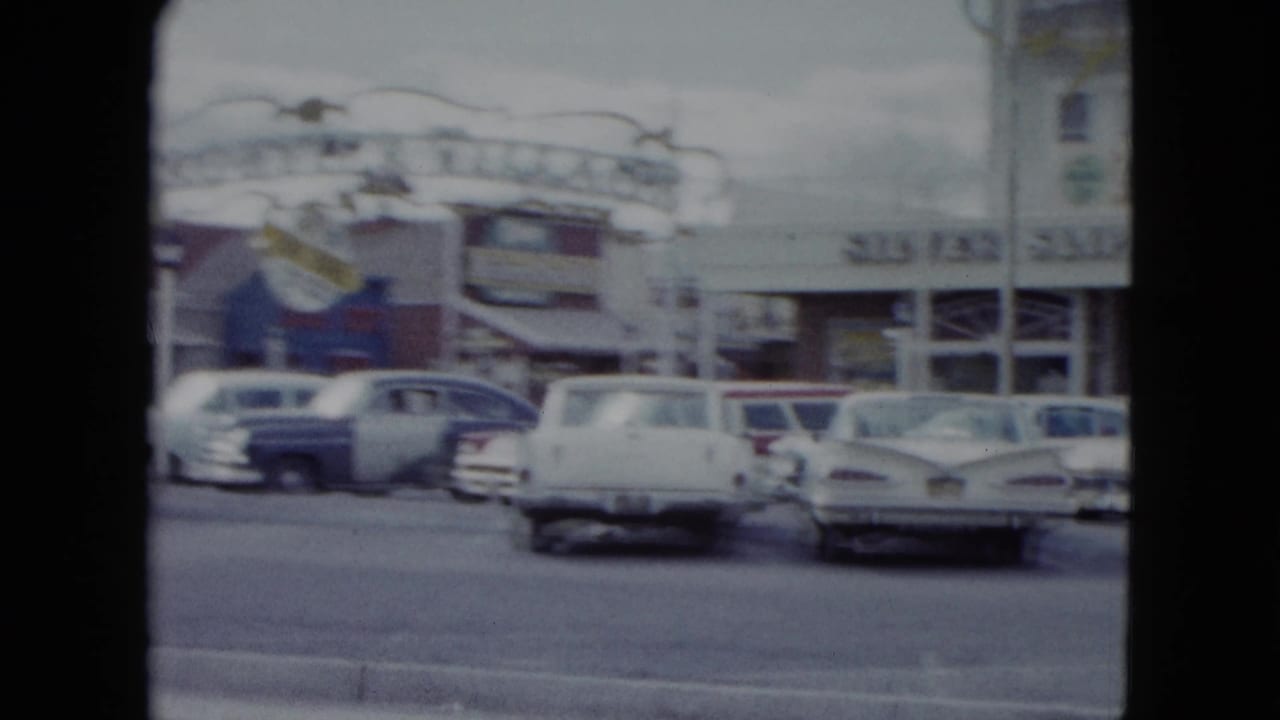 1959 Nevada frame showing the Silver Slipper sign area, roadside buildings, and classic cars near the curb.