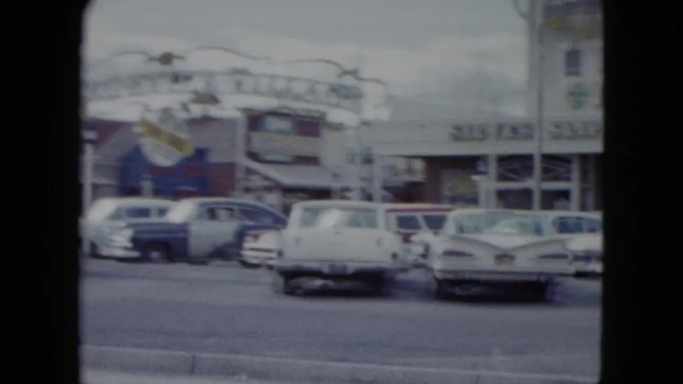 1959 Nevada frame showing the Silver Slipper sign area, roadside buildings, and classic cars near the curb.