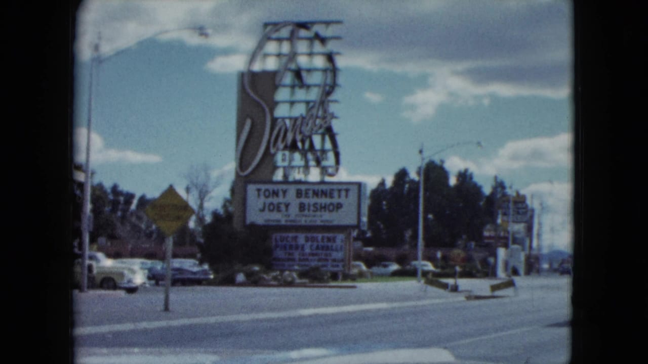 1959 Nevada frame with the Sands sign and marquee naming Tony Bennett and Joey Bishop, with cars and roadside signs nearby.