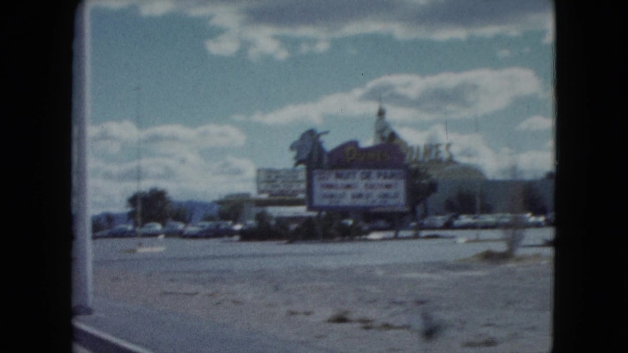 Roadside casino sign and marquee seen from a moving car beside a wide road.