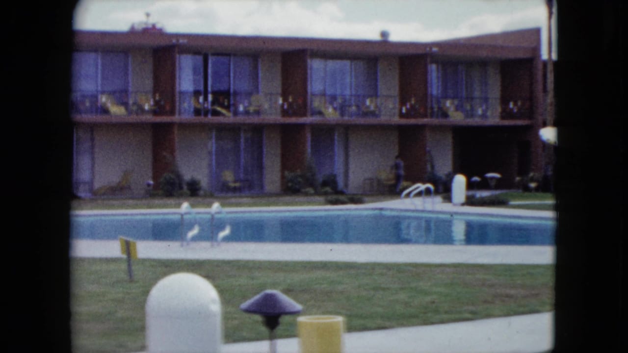 A quiet Nevada poolside courtyard appears in 8mm footage, with balcony rooms, lawn, pool ladder, and outdoor fixtures.
