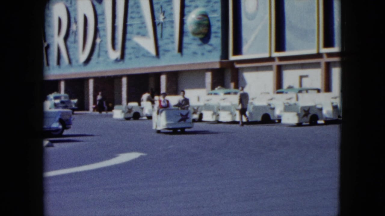 Stardust Hotel facade with parked cars and a white motorized cart in the foreground.