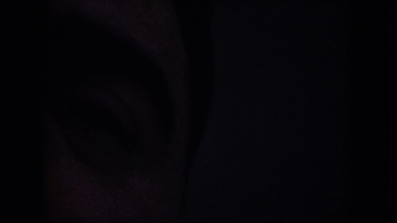 Obscured opening frame from a 1959 8mm Nevada desert clip, with most of the view hidden in darkness.