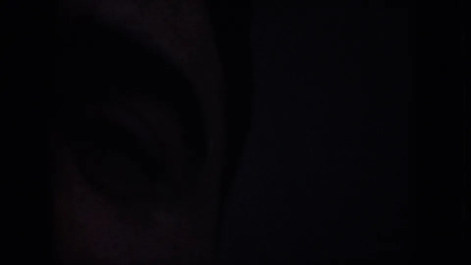 Obscured opening frame from a 1959 8mm Nevada desert clip, with most of the view hidden in darkness.
