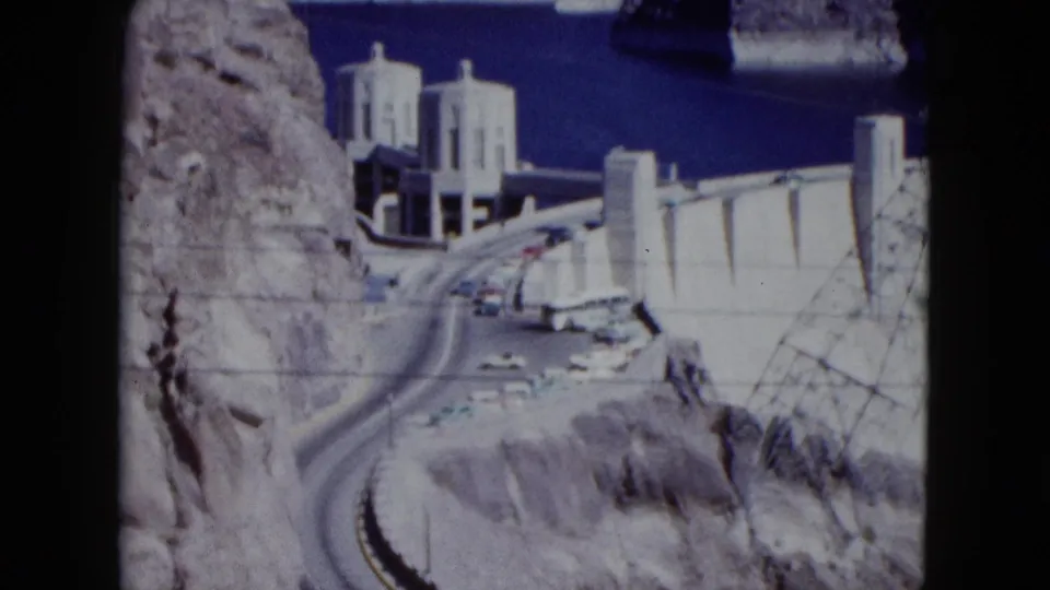 1959 Nevada home-movie view of the Hoover Dam approach, with cars on the road and Lake Mead visible beyond.