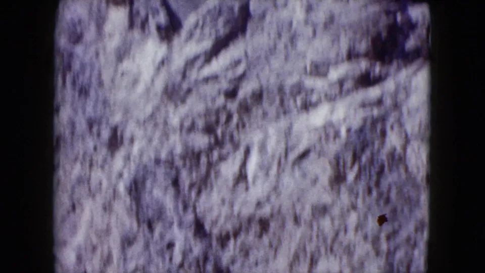 Handheld 1959 8mm view of a rocky Nevada slope, softened by motion blur and film grain.