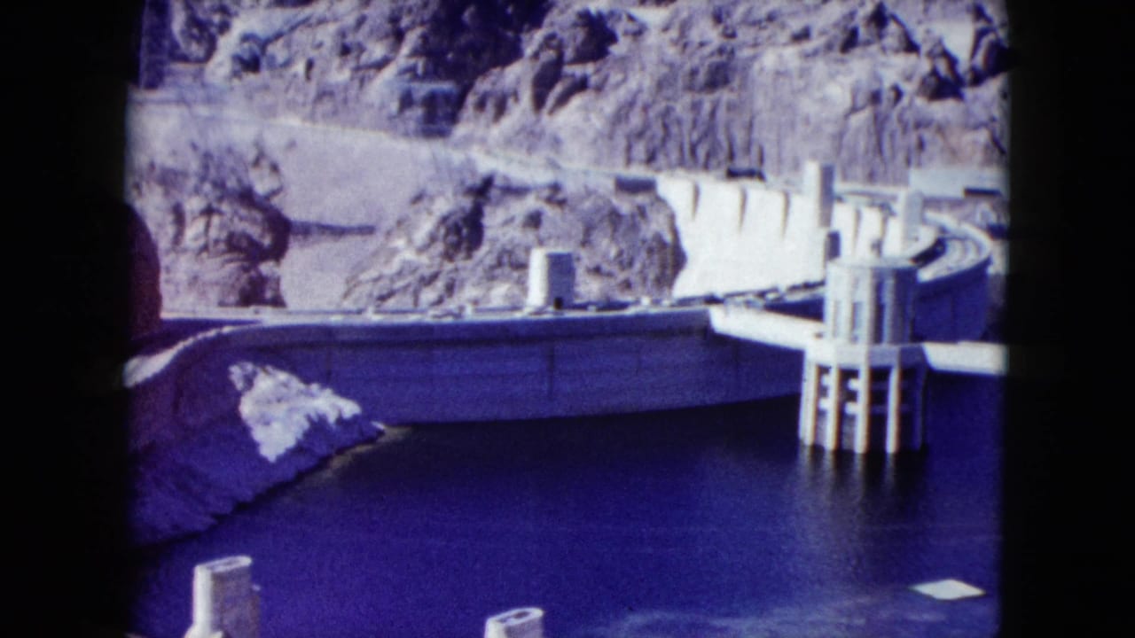 Hoover Dam and reservoir seen between rocky canyon walls.