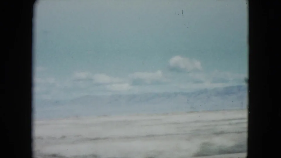 Soft 8mm view of a Nevada desert plain and mountain range, with no people visible in this frame.