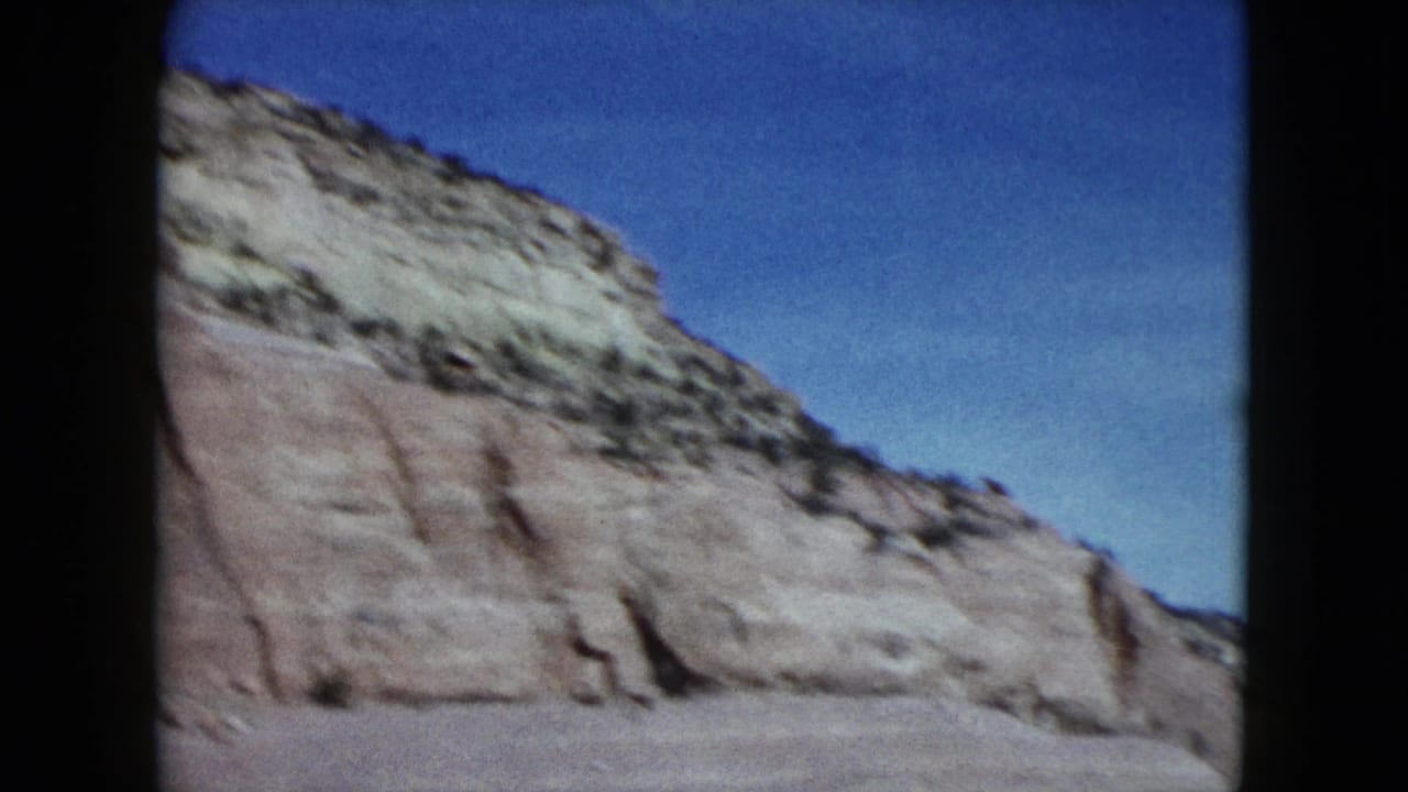 Pale cliff slope fills the frame beneath a blue sky.