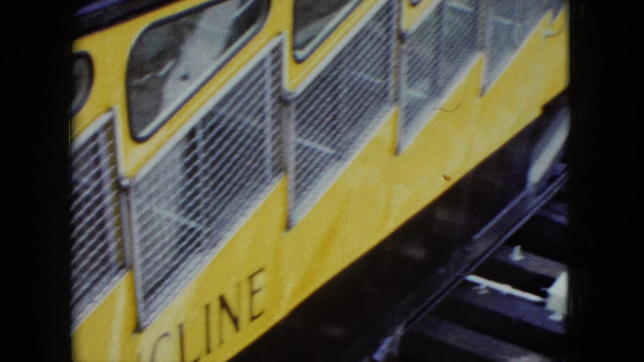 Close 1959 Nevada view of the yellow incline railway car body, showing barred windows, vents, and partial MOUNTAIN INCLINE text.