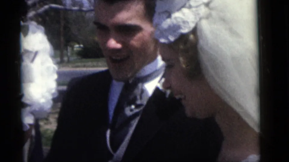 A close view shows the groom smiling beside the bride in her white veil during the Camden wedding home movie.