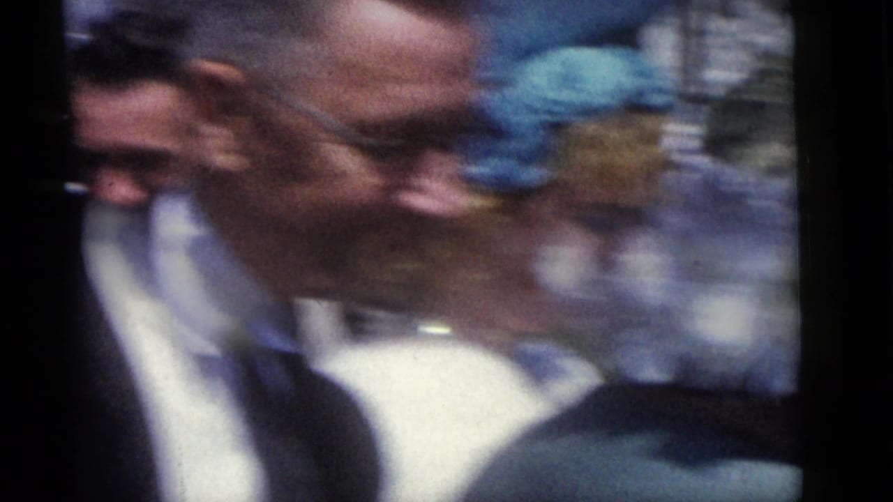 In Camden, New Jersey wedding footage from 1960, blurred men in formalwear move past the handheld 8mm camera outdoors.