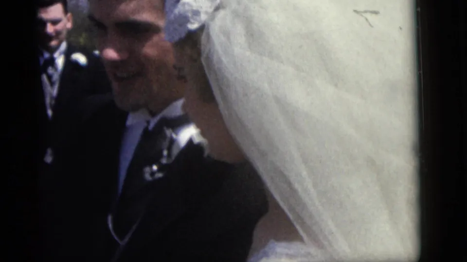 The bride in a white veil appears beside the groom and suited attendants in the 1960 Camden wedding home movie.
