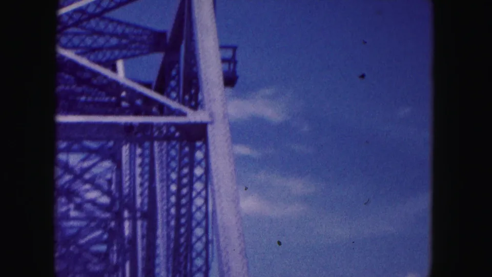 1960 Miami-area home-movie frame showing a partial metal bridge structure beside blue water and sky.