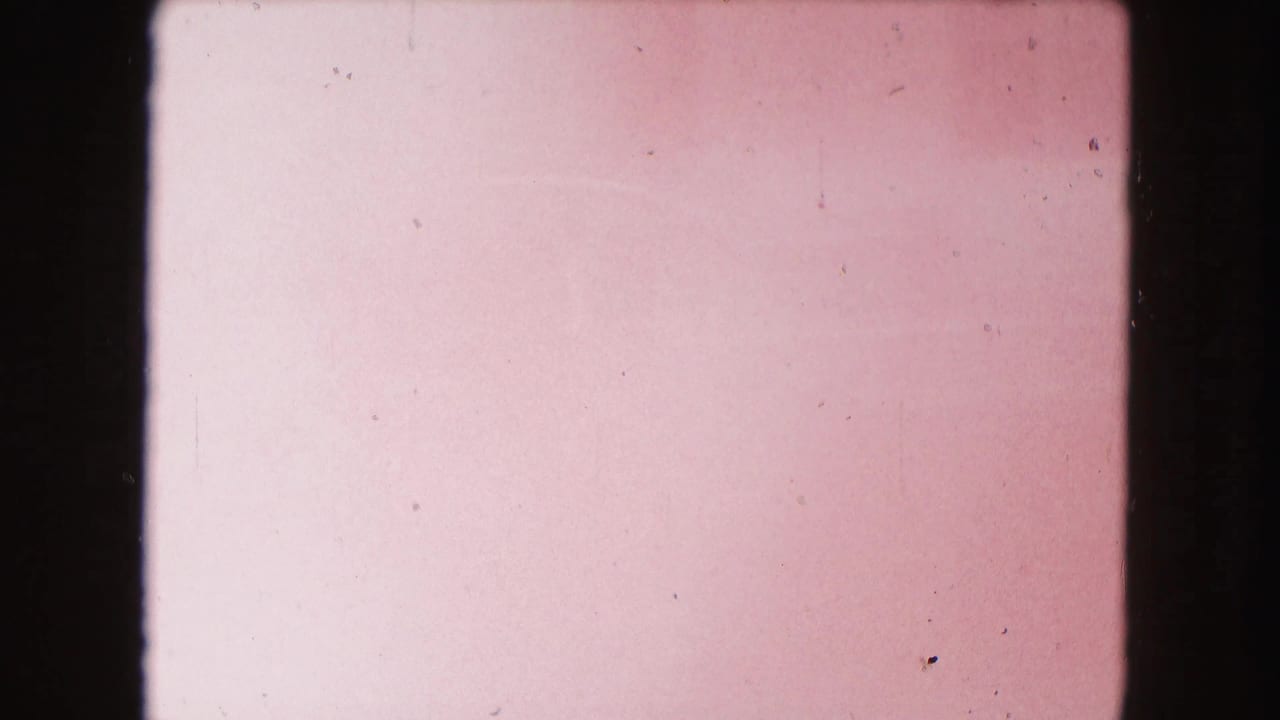 Mostly overexposed pink film frame with dust, scratches, and dark film gate borders.