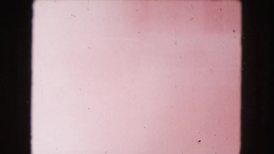 Overexposed 8mm frame from the 1960 Miami clip, showing pink color fading, dust, scratches, and no clear subject detail.