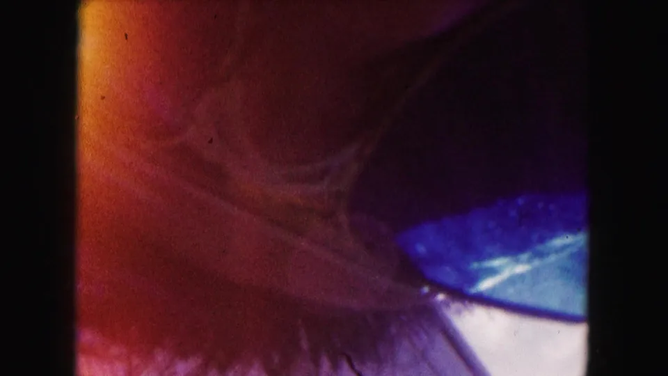 1960 Miami 8mm frame showing the spinning cup as a dark red-purple blur with a blue highlight and heavy film border.