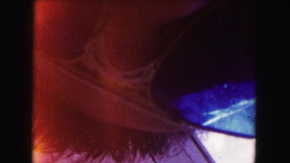Opening 8mm frame with heavy film border, red-blue exposure flare, and a partial Miami street view visible at the right edge.