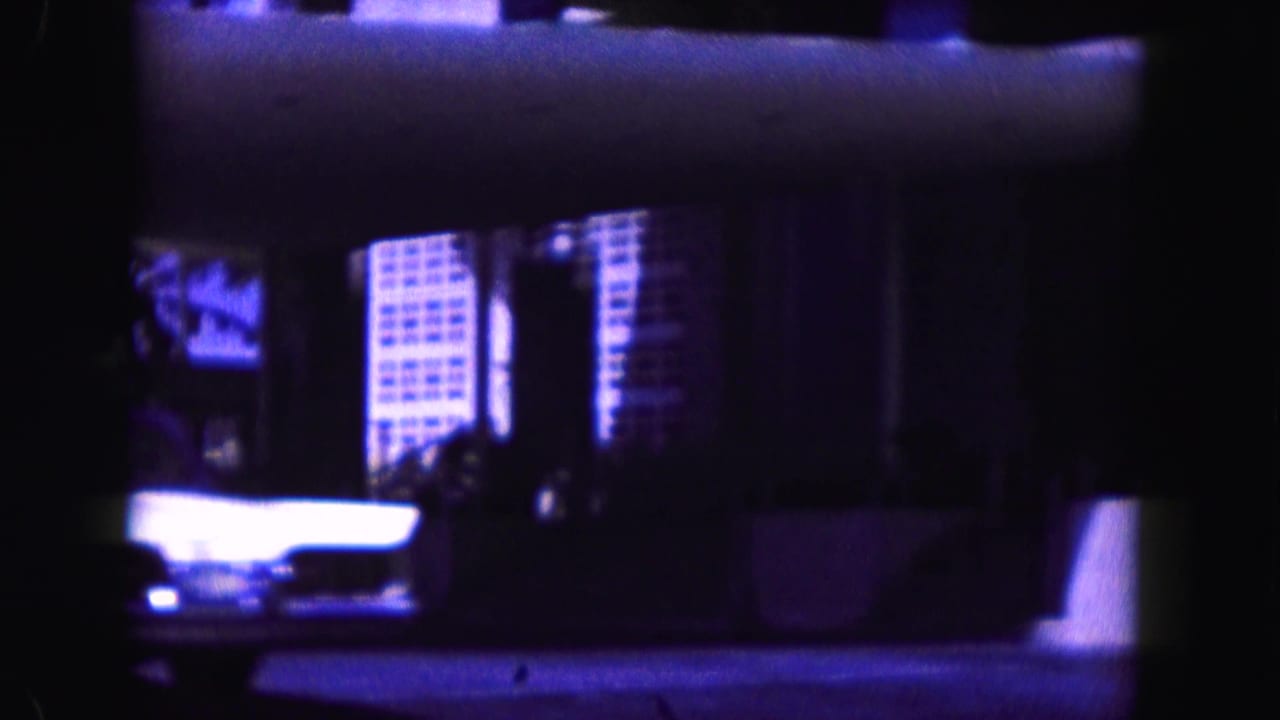 Dark, soft street view with building windows and strong blue-purple film tint.