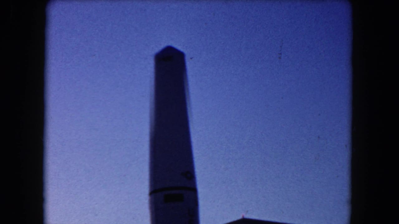 Close view of the upper section of a rocket replica against a blue sky.