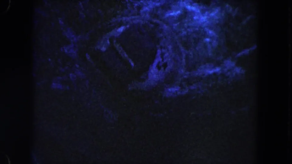 Grainy 1960 Miami frame with murky blue water and indistinct pale underwater forms.