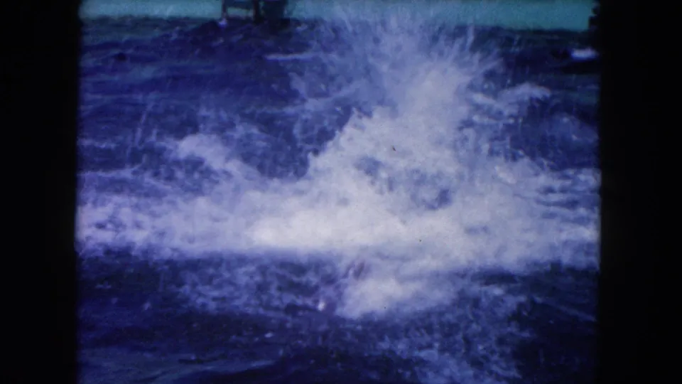 1960 Miami home-movie frame dominated by a large splash after dolphin movement in the pool.