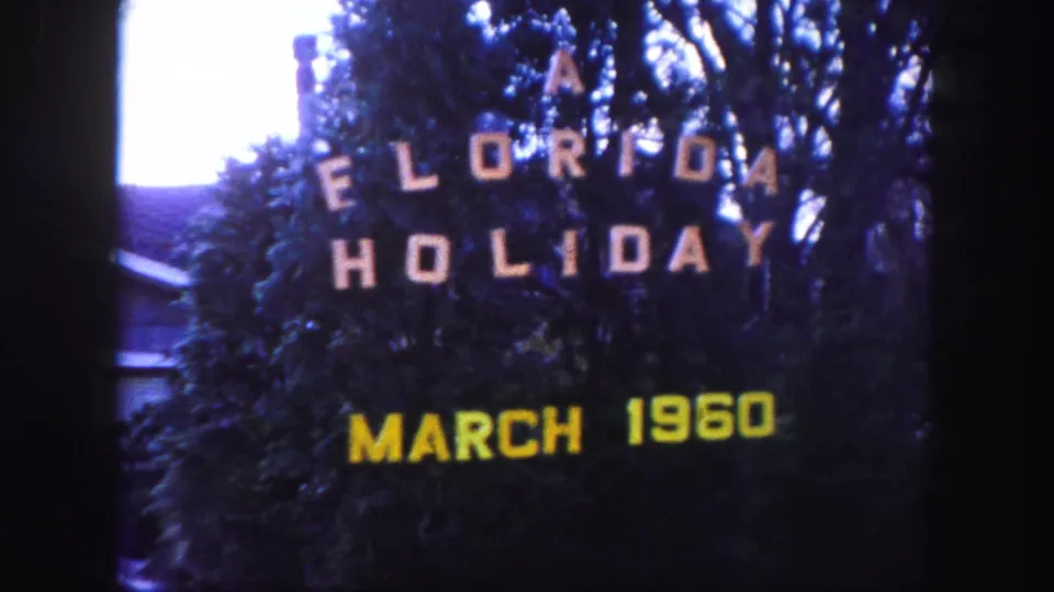 1960 Florida home-movie title card with white vacation lettering and yellow March 1960 date over dark foliage.