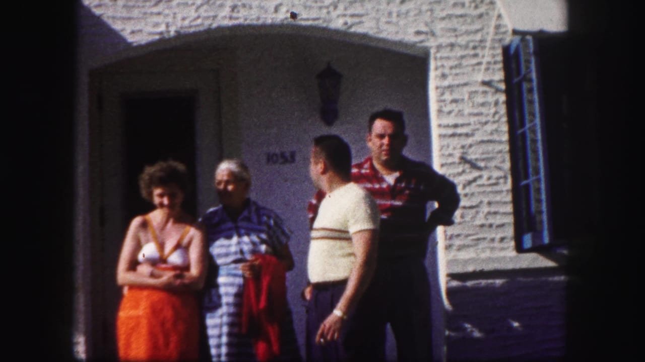 The family group remains outside the Tampa house, with one man turned in profile while others face the camera.