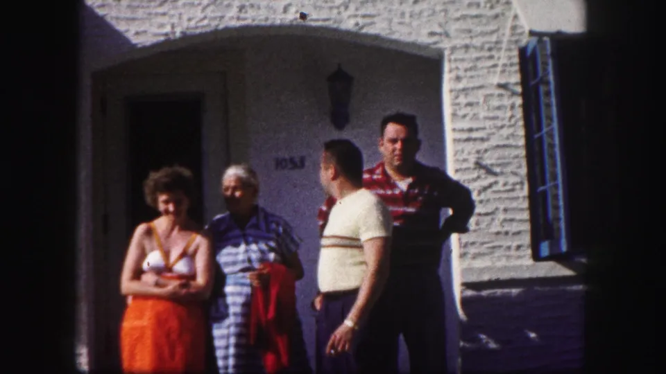 The family group remains outside the Tampa house, with one man turned in profile while others face the camera.
