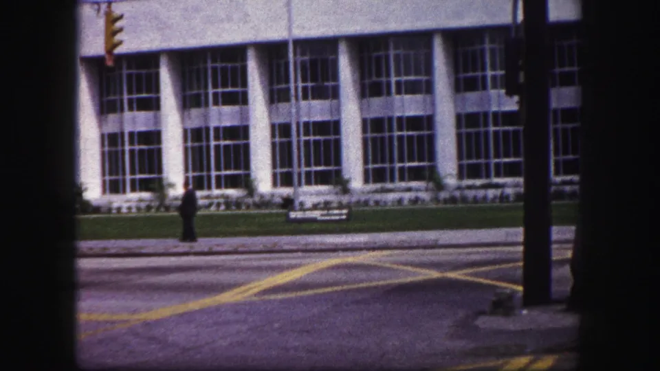 End frame of the 1960 Tampa street view, with pedestrians mostly cleared and the large-window building across the road.