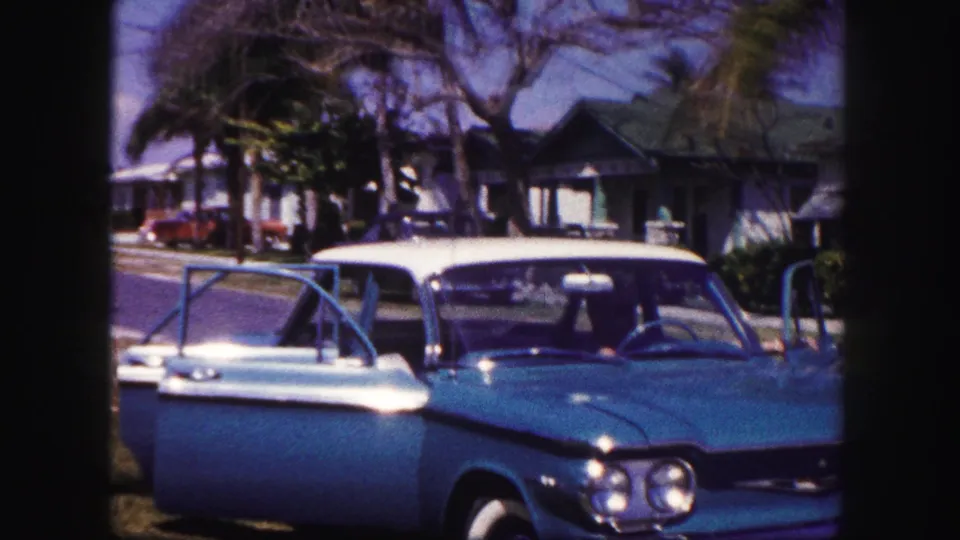 The 1960 Tampa scene shows the turquoise car facing the camera with open doors and palm-lined houses behind it.