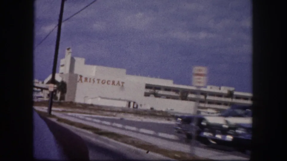 The final 1960 Tampa frame shows the Aristocrat building, crosswalk lines, a passing car, street poles, and open sky.